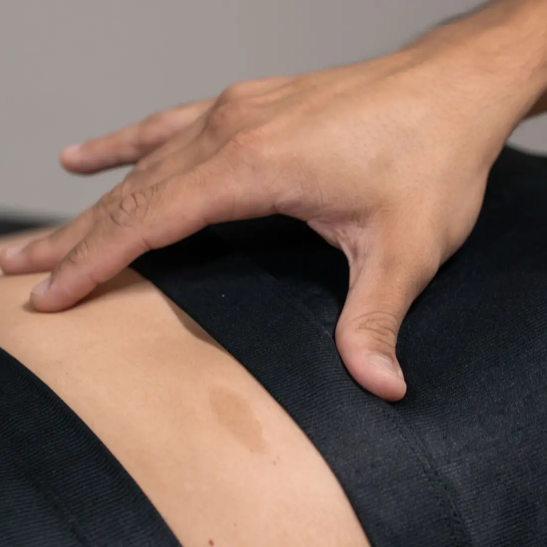 Mão do fisioterapeuta apoiada no abdômen da paciente em técnica manual