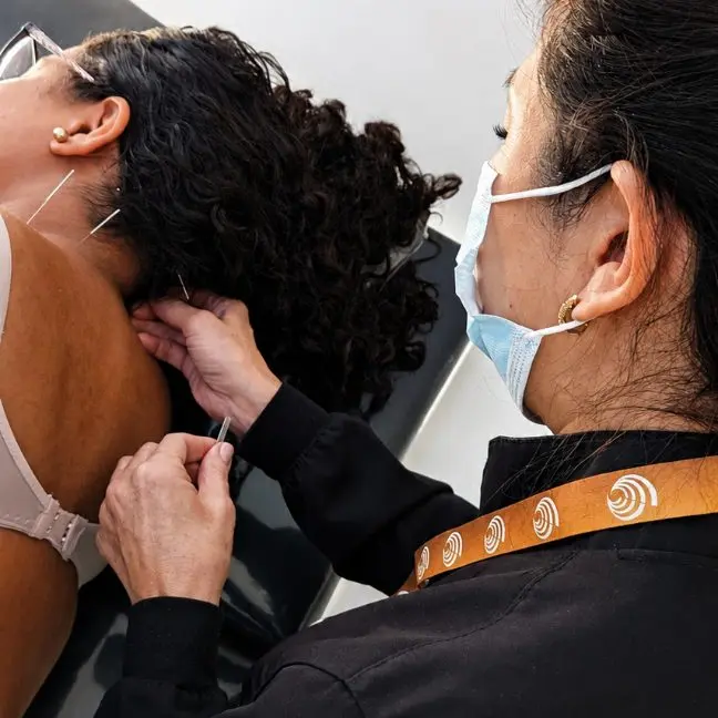 Profissional da Ampiezza realiza atendimento na região cervical de paciente sentado