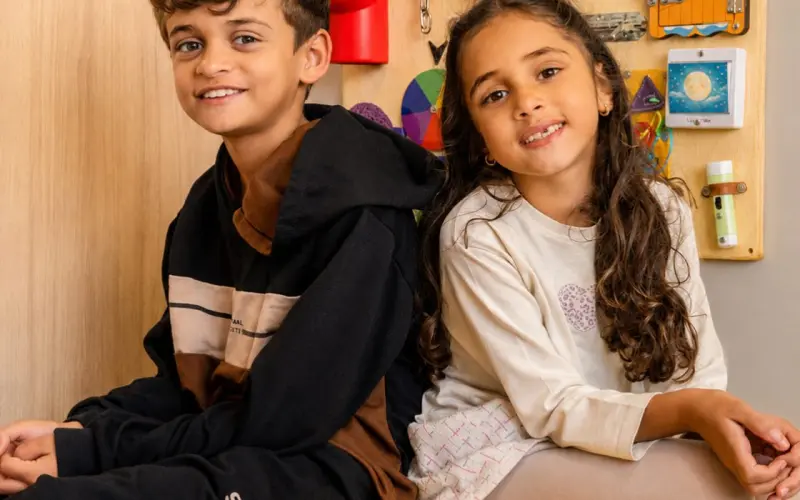 Duas crianças sorridentes na sala de atendimento infantil Ampiezza Petit